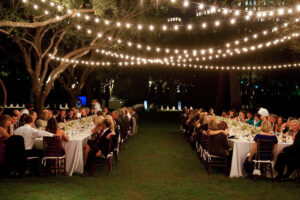 Night wedding with tables sat outside under string lights.