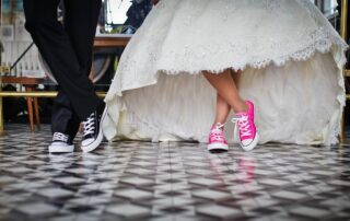 Bride and groom with converse on. Bride in pink and groom in black.