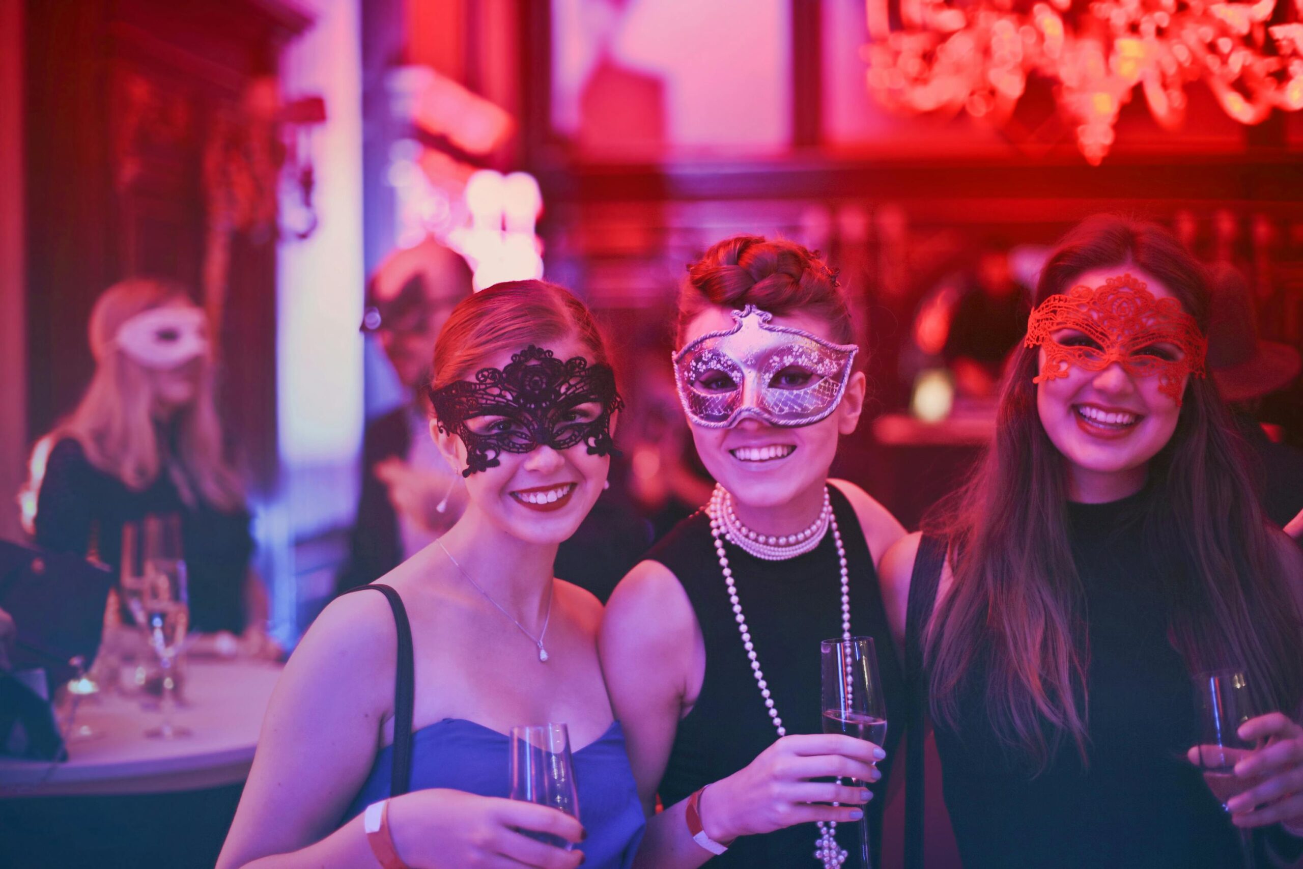 Three women in masks at party