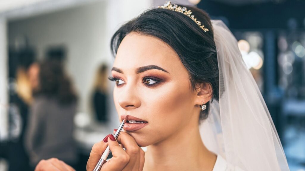 Bride putting on wedding makeup